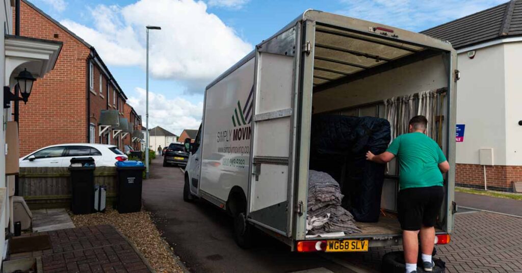 Simply Moving crew member loading a removal van outside a house
